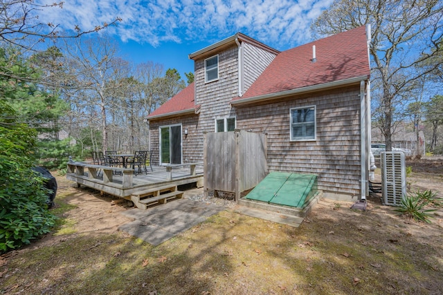 rear view of house with a deck and a shingled roof