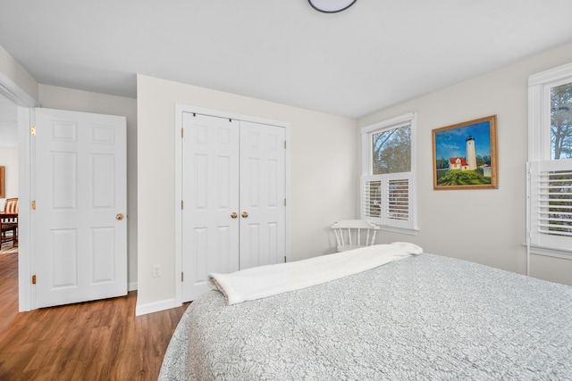 bedroom featuring a closet, baseboards, and wood finished floors