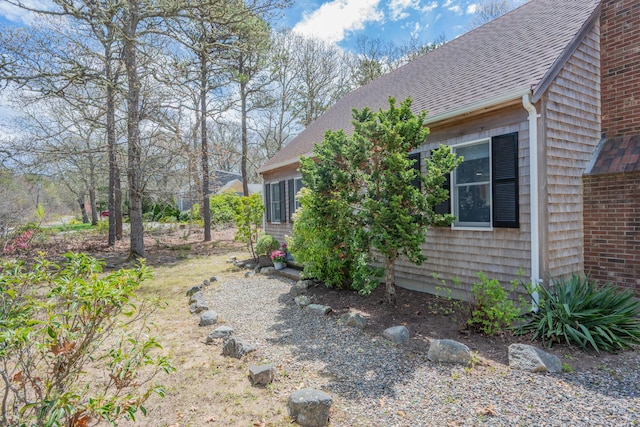 view of side of property featuring roof with shingles