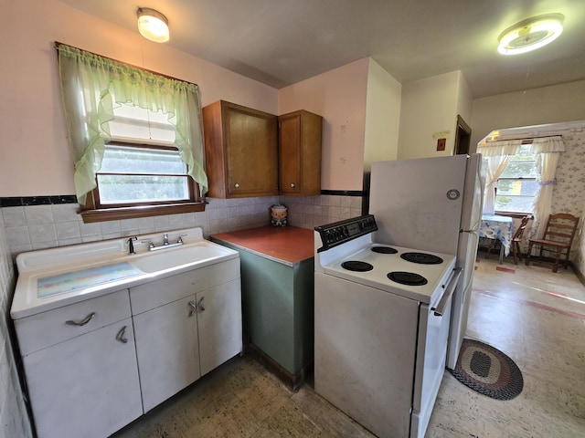 57 Cedar Hill Rd, Brewster, MA 02631 - kitchen with white range with electric stovetop, light flooring, brown cabinets, light countertops, and tasteful backsplash