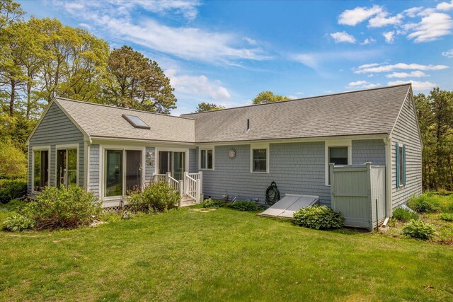back of house with a yard and a shingled roof