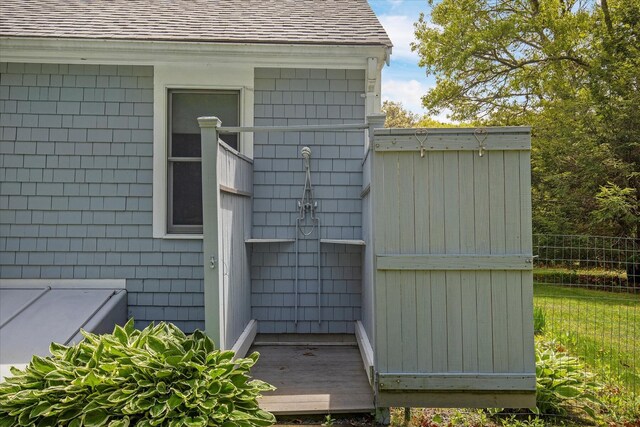 property entrance featuring a shingled roof