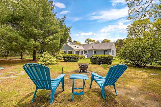 view of green lawn featuring a fire pit