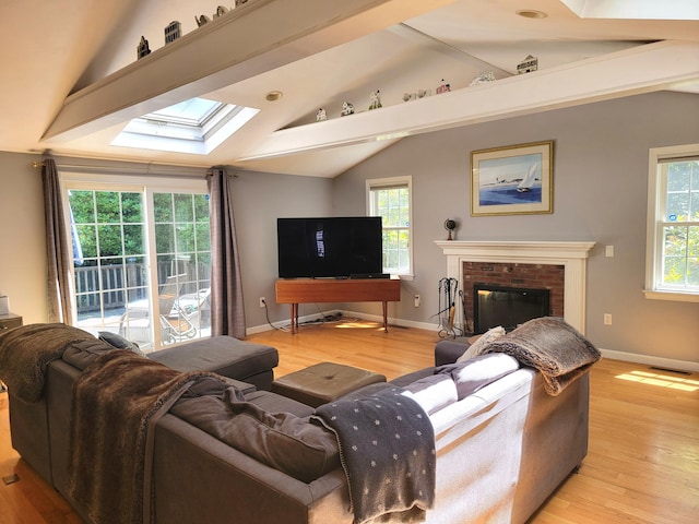 13 Quail Hollow Cir, Sandwich, MA 02563 - living room with a skylight, vaulted ceiling, light wood-style flooring, a brick fireplace, and baseboards