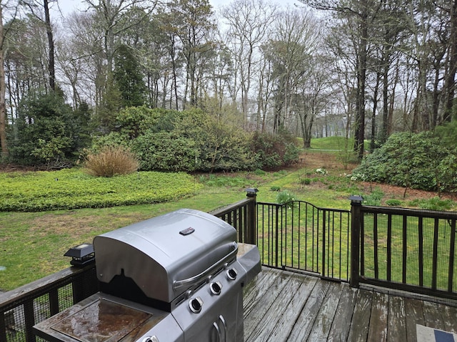 wooden deck featuring a grill and a yard