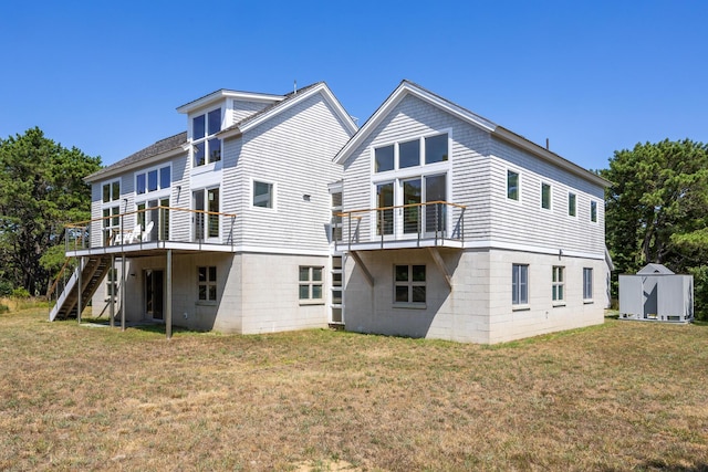 back of house featuring a wooden deck, a yard, and a shed