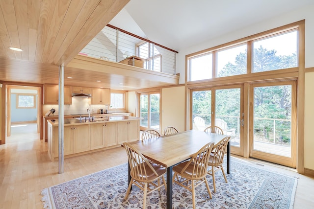 dining room with sink, wooden ceiling, light hardwood / wood-style flooring, and high vaulted ceiling