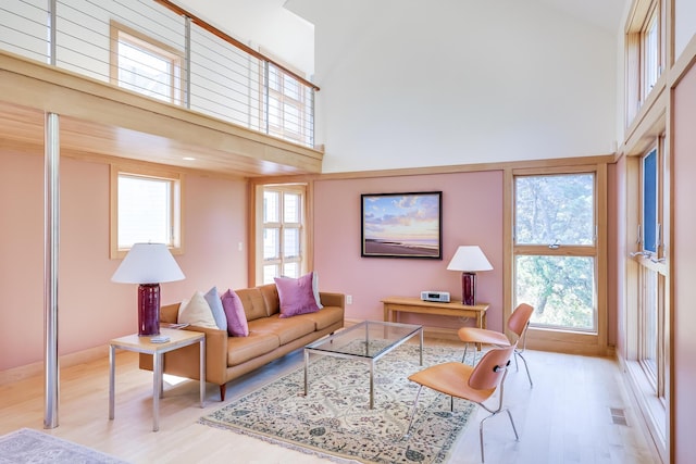 living room featuring light wood-type flooring and a high ceiling