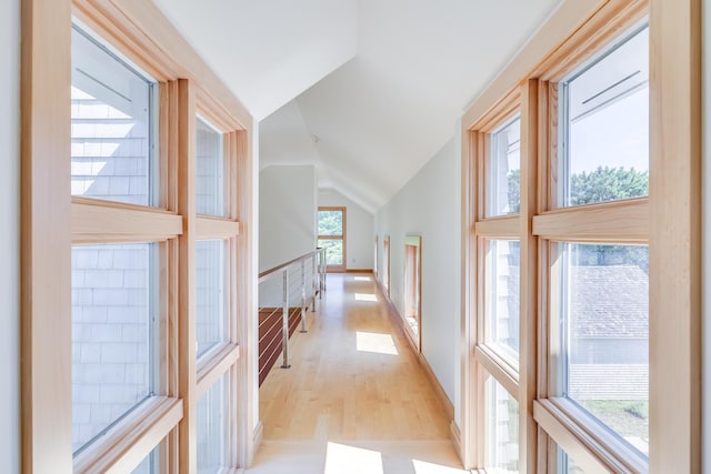 hallway featuring lofted ceiling and light wood-type flooring