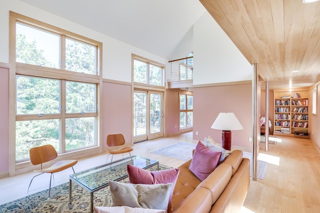 living room featuring built in features, light wood-type flooring, a high ceiling, and wooden ceiling