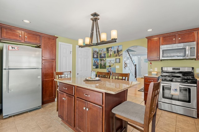 44 Buttermilk Way, Buzzards Bay, MA 02532 - kitchen with stainless steel appliances, arched walkways, light tile patterned floors, light stone countertops, and recessed lighting