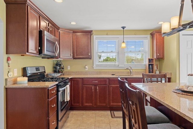 44 Buttermilk Way, Buzzards Bay, MA 02532 - kitchen featuring appliances with stainless steel finishes, a sink, a breakfast bar area, light stone countertops, and decorative light fixtures