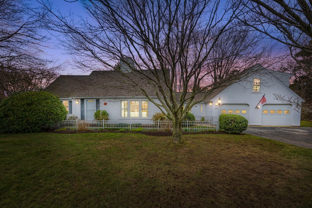 278 Riverview Ln, Centerville, MA 02632 - view of front of home featuring a garage, driveway, fence private yard, a front yard, and roof with shingles