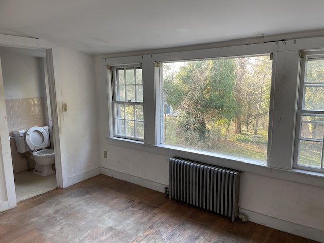 spare room with radiator and dark hardwood / wood-style flooring