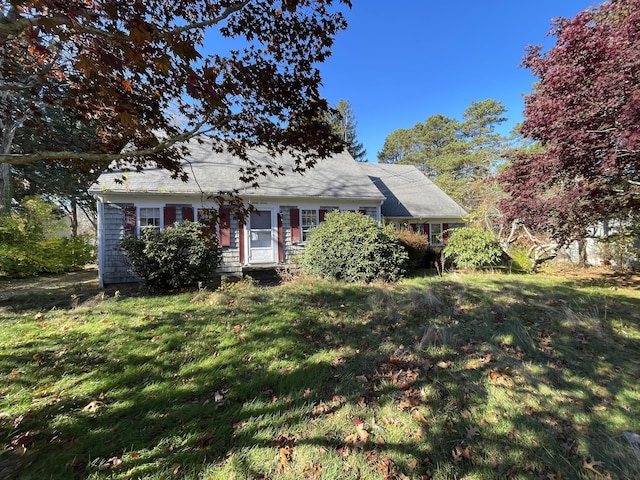 cape cod home with a front lawn