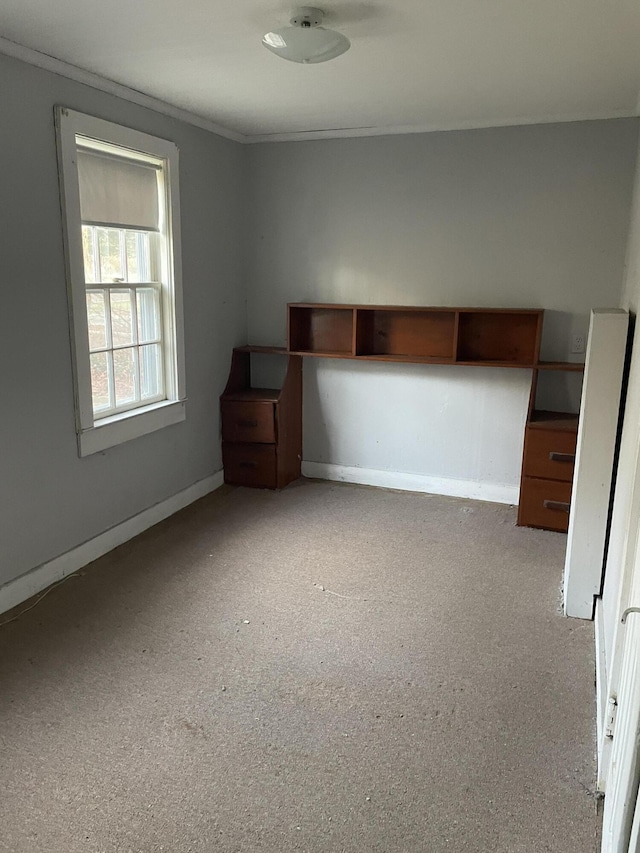 unfurnished bedroom with ornamental molding and light carpet