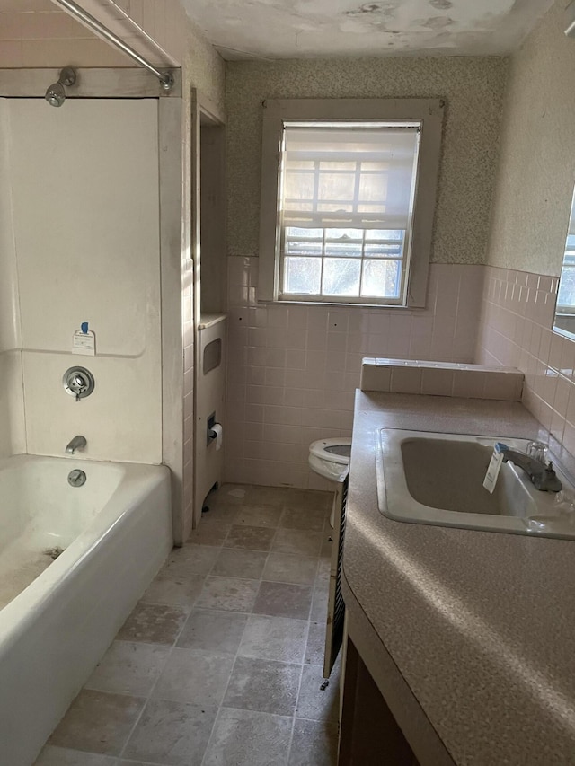 full bathroom with shower / bath combination, tile walls, toilet, and vanity