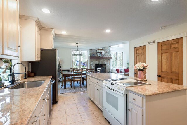 532 S Orleans Rd, Orleans, MA 02653 - kitchen featuring electric range, a center island, a stone fireplace, white cabinetry, and light tile patterned floors