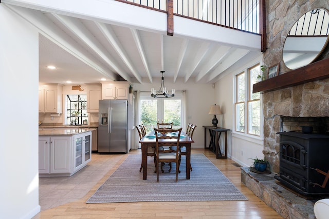 532 S Orleans Rd, Orleans, MA 02653 - dining room featuring a wood stove, a chandelier, beam ceiling, light wood finished floors, and recessed lighting