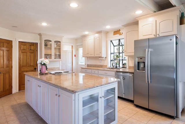 532 S Orleans Rd, Orleans, MA 02653 - kitchen with stainless steel appliances, light tile patterned floors, a center island, glass insert cabinets, and recessed lighting