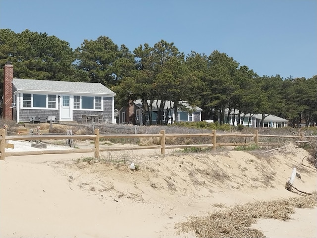 100 Hiawatha Rd Unit B, Wellfleet, MA 02667 - view of front facade featuring fence, a chimney, and roof with shingles