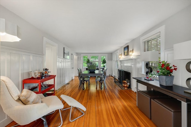 117 Parker Rd, Osterville, MA 02655 - living room featuring wood finished floors, a decorative wall, a fireplace, and wainscoting
