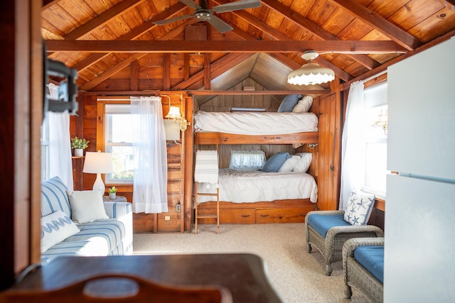 carpeted bedroom with white fridge and vaulted ceiling with beams