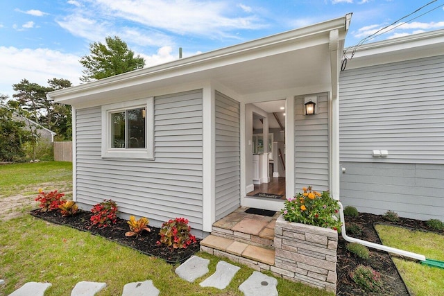 view of exterior entry featuring a yard