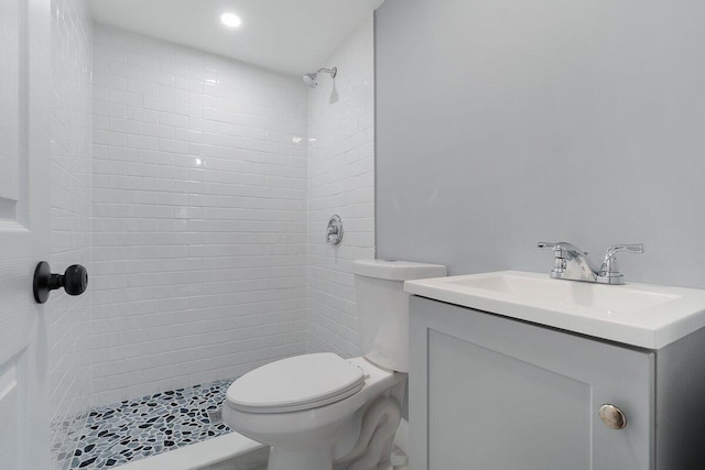 bathroom with toilet, vanity, and a stall shower