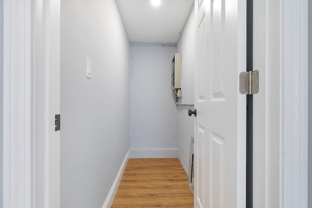 hallway featuring light wood finished floors and baseboards