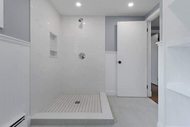 bathroom featuring recessed lighting, tiled shower, a baseboard radiator, and a wainscoted wall