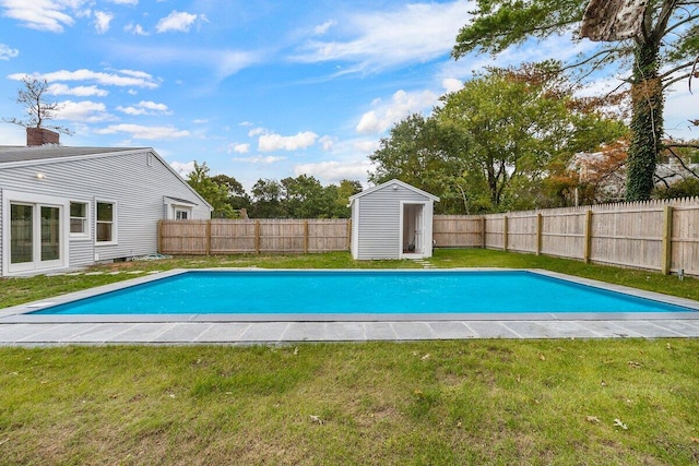 view of pool with a yard, a fenced backyard, an outdoor structure, and a fenced in pool