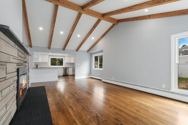 unfurnished living room with a baseboard radiator, a fireplace, beamed ceiling, dark wood-type flooring, and a baseboard heating unit