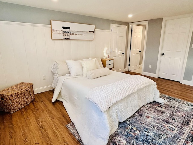 bedroom with wood finished floors, baseboards, and recessed lighting