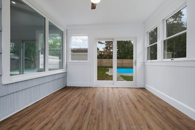 unfurnished sunroom with a ceiling fan and wood finished floors