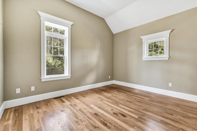 bonus room with a healthy amount of sunlight, light hardwood / wood-style floors, and lofted ceiling