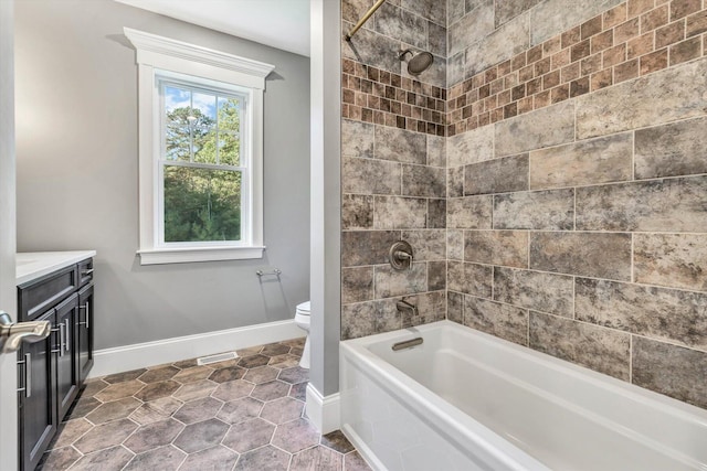 full bathroom with vanity, toilet, and tiled shower / bath combo