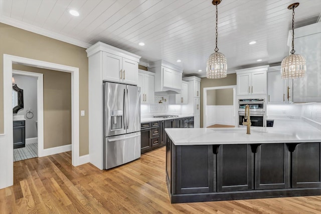 kitchen featuring white cabinets, stainless steel appliances, and hanging light fixtures