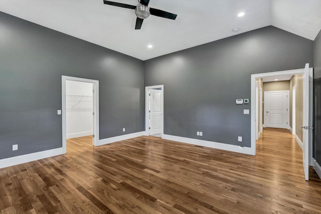 empty room with hardwood / wood-style flooring, lofted ceiling, and ceiling fan