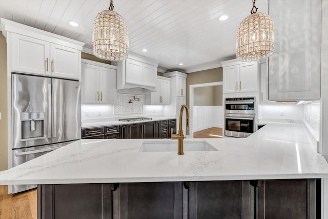 kitchen with white cabinetry, sink, pendant lighting, and a notable chandelier