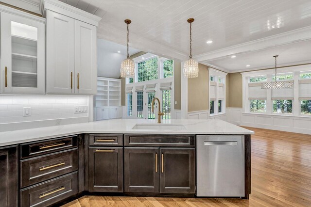 kitchen featuring pendant lighting, dishwasher, sink, a wealth of natural light, and light hardwood / wood-style floors