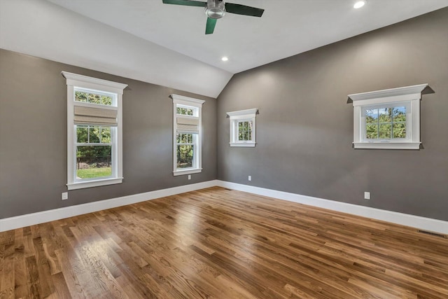 empty room with hardwood / wood-style flooring, lofted ceiling, and ceiling fan