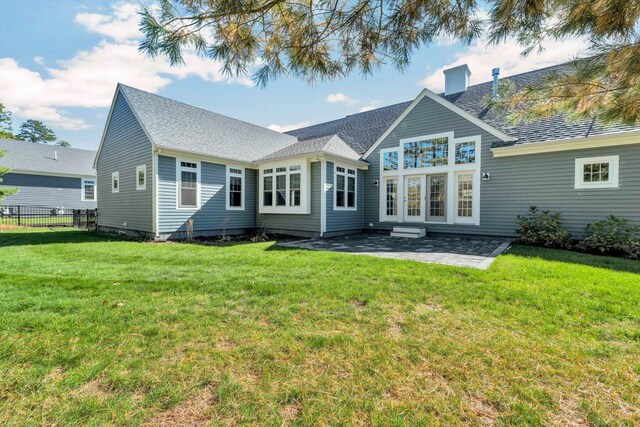 rear view of property featuring a patio and a lawn