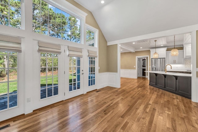 unfurnished living room with sink, hardwood / wood-style floors, and plenty of natural light