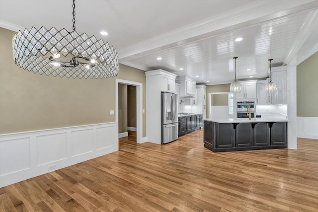 kitchen with decorative light fixtures, white cabinets, light hardwood / wood-style floors, a chandelier, and stainless steel appliances