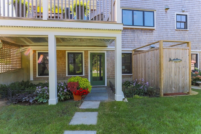 property entrance with a balcony and a lawn