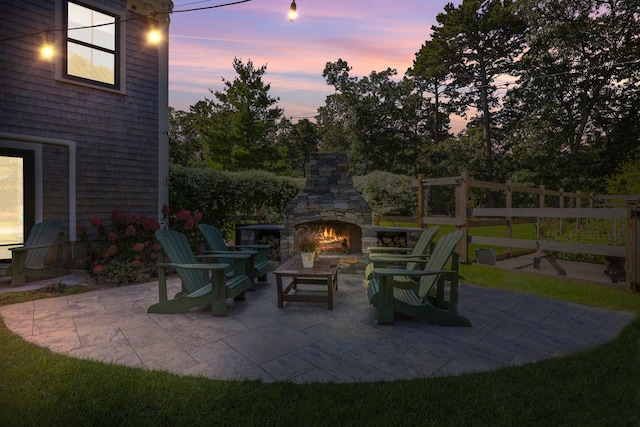 patio terrace at dusk with an outdoor stone fireplace