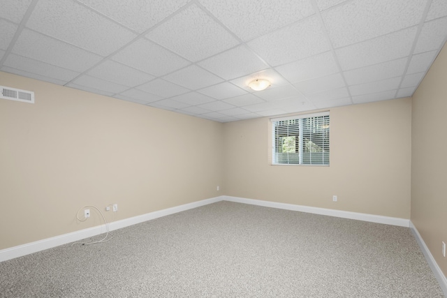 empty room featuring baseboards, visible vents, a drop ceiling, and carpet