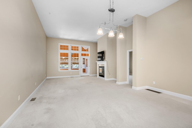 unfurnished living room with baseboards, light carpet, and visible vents