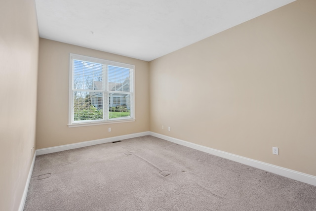 unfurnished room featuring baseboards and light carpet